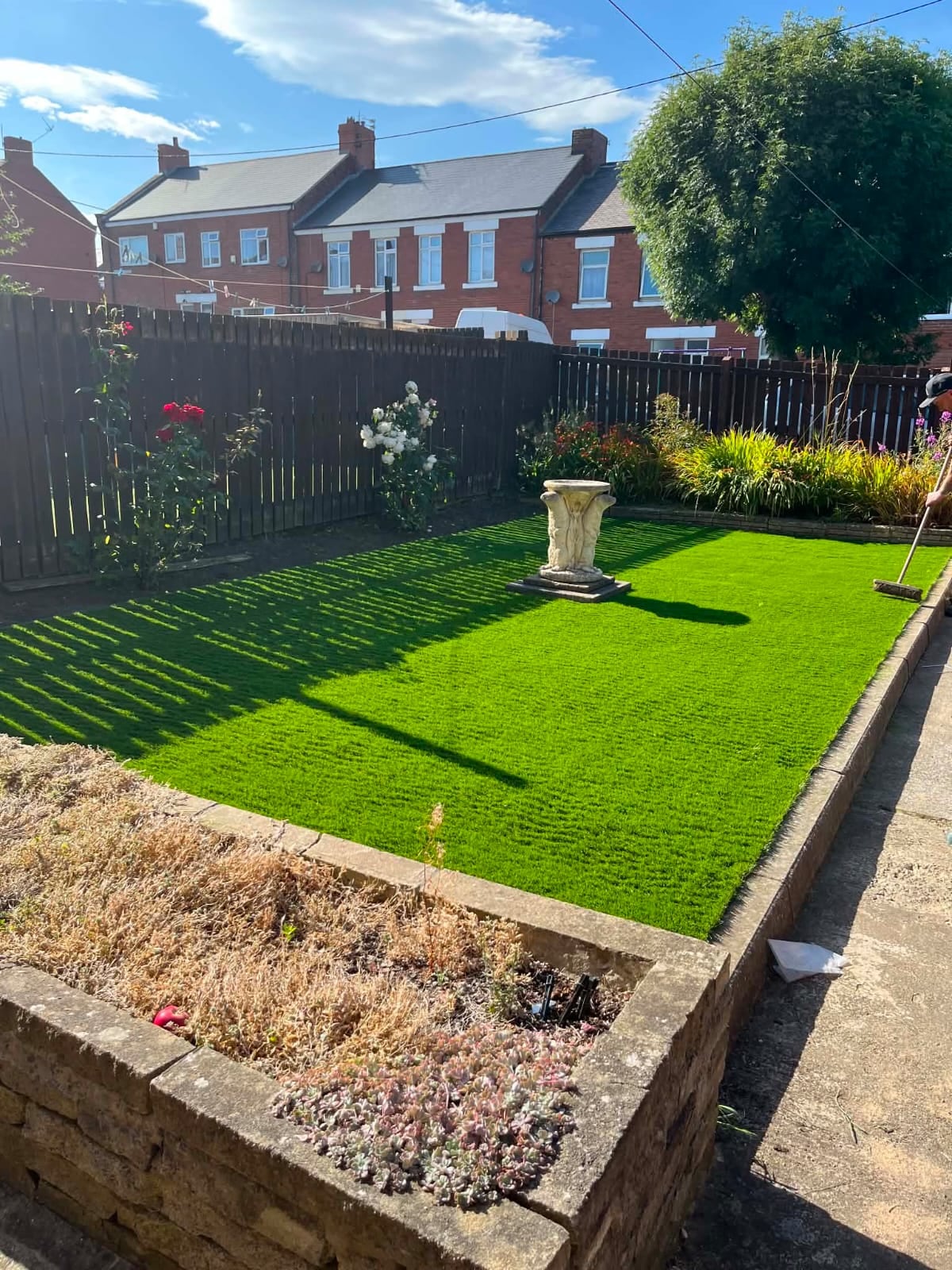 Finished artificial lawn with gravel edging by Ashurst and Sons Roofing